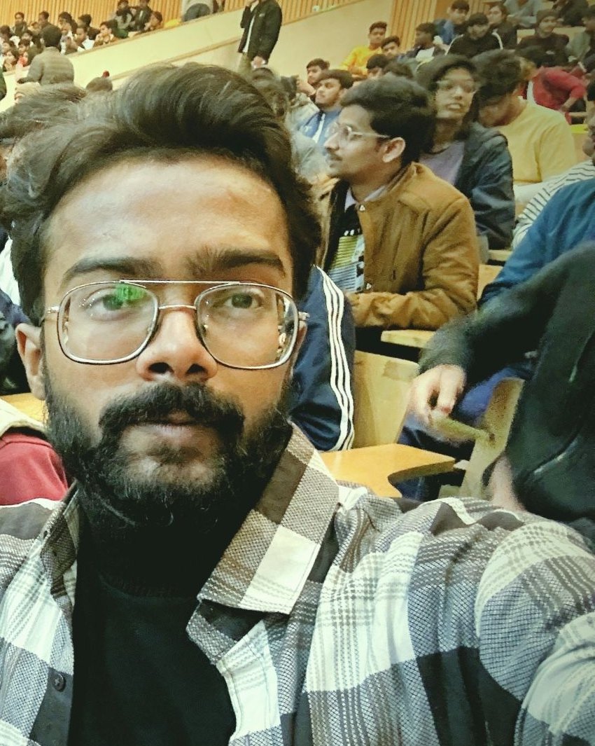Pranjul Rathour in a checked shirt inside a packed college auditorium
