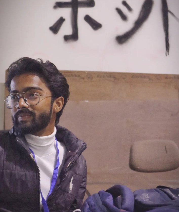 Pranjul Rathour seated in a black jacket and white turtleneck with an event lanyard