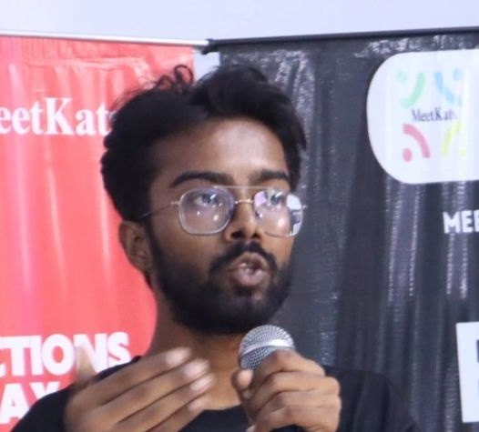 Pranjul Rathour speaking into a microphone on stage at a MeetKats event